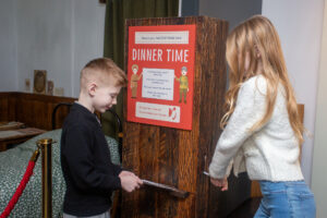 Two young people stamping a factory pass inside The Devil's Porridge Museum.