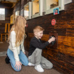 Two young people exploring The Devil's Porridge Museum's replica World War One Trench.