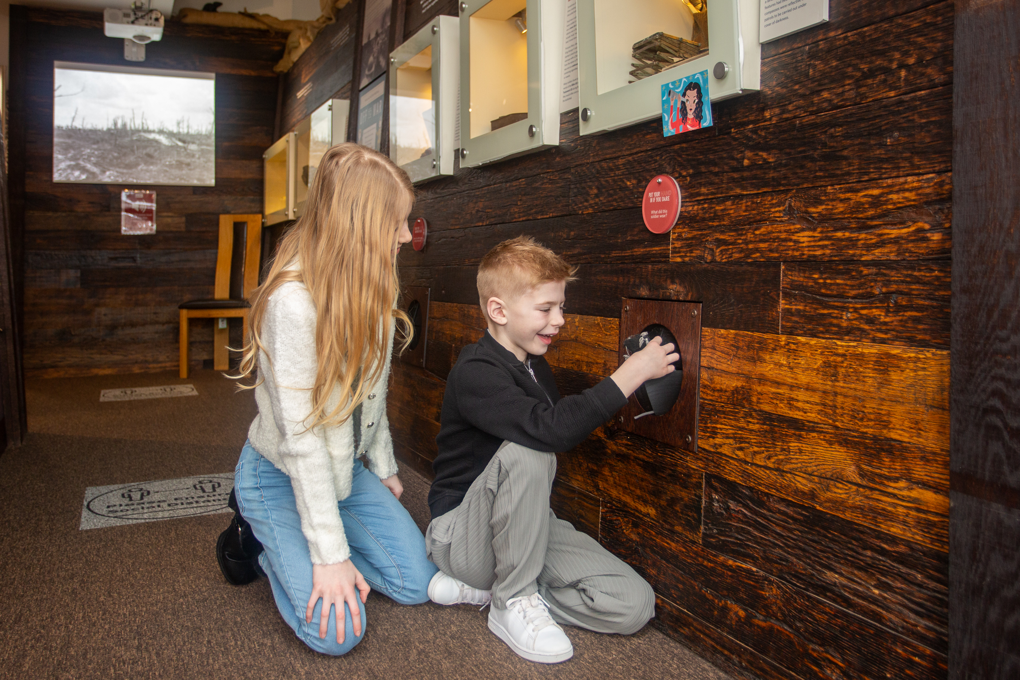 Two young people exploring The Devil's Porridge Museum's replica World War One Trench.