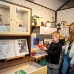 Two young people enjoying The Devil's Porridge Museum's interactive 1940s house display.