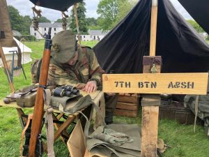 A living history re-enactor with a tent and display outside.