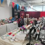 The Devil's Porridge Museum's Education room filled with tables adorned with handmade items, gifts and crafts made by the Scotia Crafters.