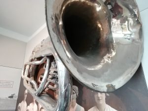 Tuba used by the factory band on display on a wall in The Devil's Porridge Museum.
