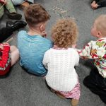 Some children sat on the floor playing pick up sticks.