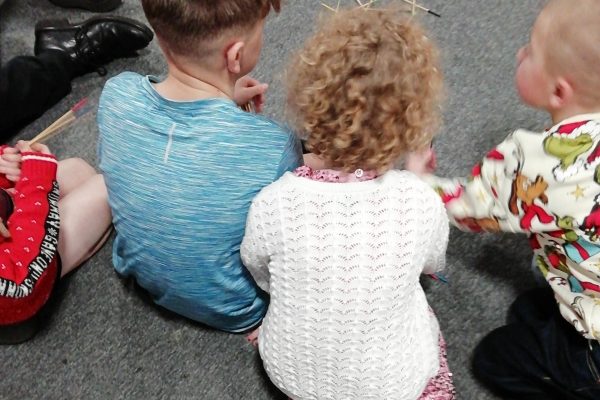 Children's Christmas Party 2025 16. Some children sat on the floor playing pick up sticks.