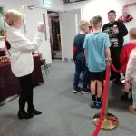 Some Children gathered around The Devil's Porridge Museum's Youth and Community Engagement Officer. The museum's Office Manager looks as if she is about to throw a snowball at him.