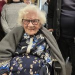 One hundred and four year old Helen with some members of her family behind her. They all look happy.