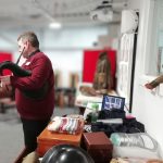 The Devil's Porridge Museum's Youth and Community Engagement Officer, Tom stood playing the bagpipes. The table behind him is covered with World War Two related items.