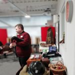 The Devil's Porridge Museum's Youth and Community Engagement Officer, Tom stood playing the bagpipes. The table behind him is covered with World War Two related items.