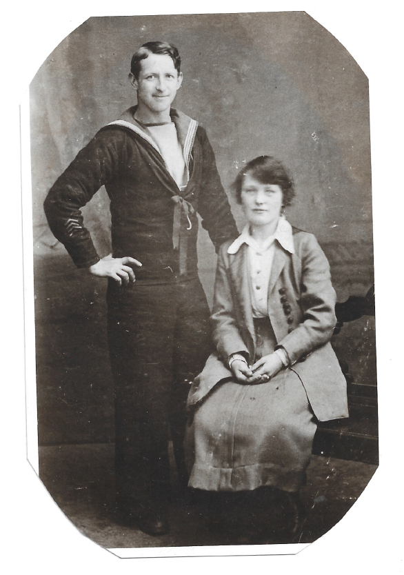 Margaret Orman sat on a chair. A man in a sailors uniform is stood to her left. This is a black and white photo from the past, which has kindly been shared by Margaret's relatives.