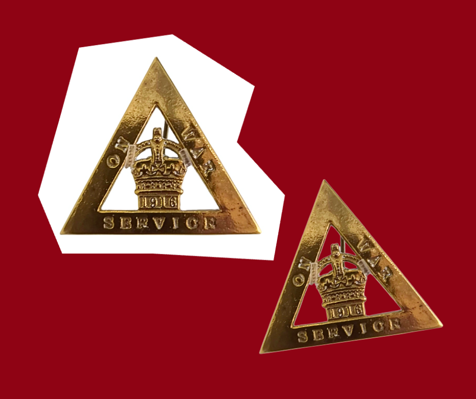 Two triangle shaped brass On War Service badges. These badges each have a crown inside a triangle.