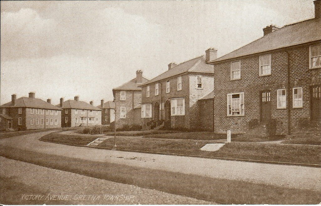 A street lined with brick houses. This is Victory Avenue in Gretna.